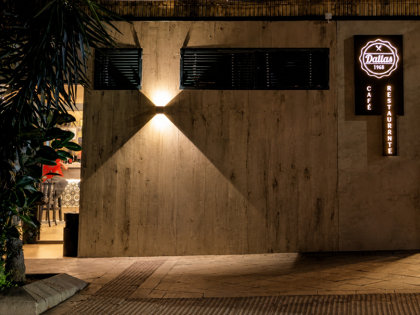 Fachada iluminada de Dallas con el rótulo de neón por la noche